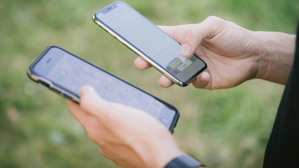 2台のスマホを持っている男性の手